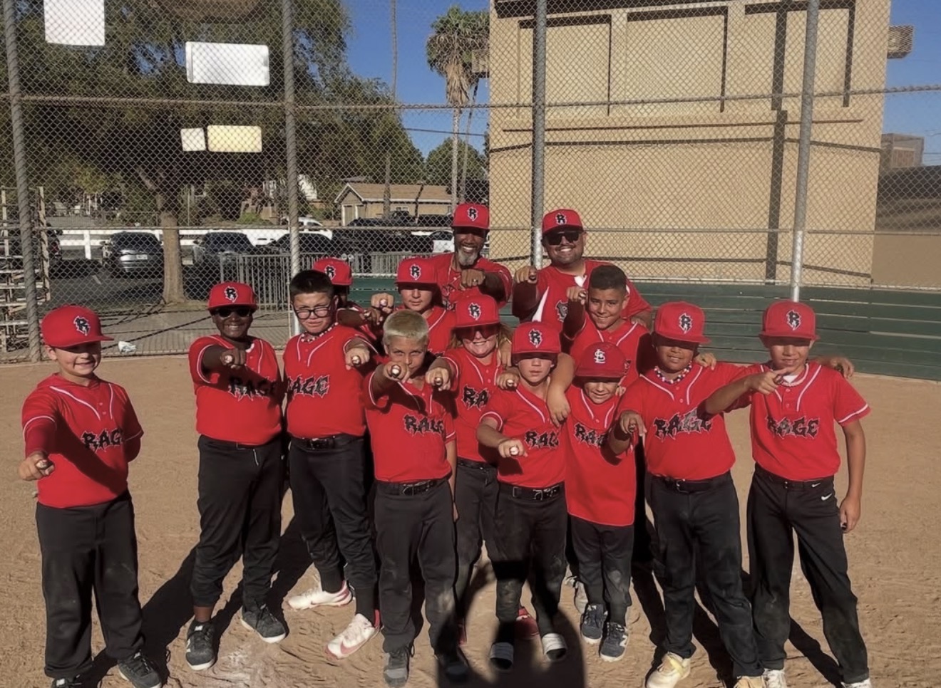 Rage Baseball team showing off their championship rings on the field